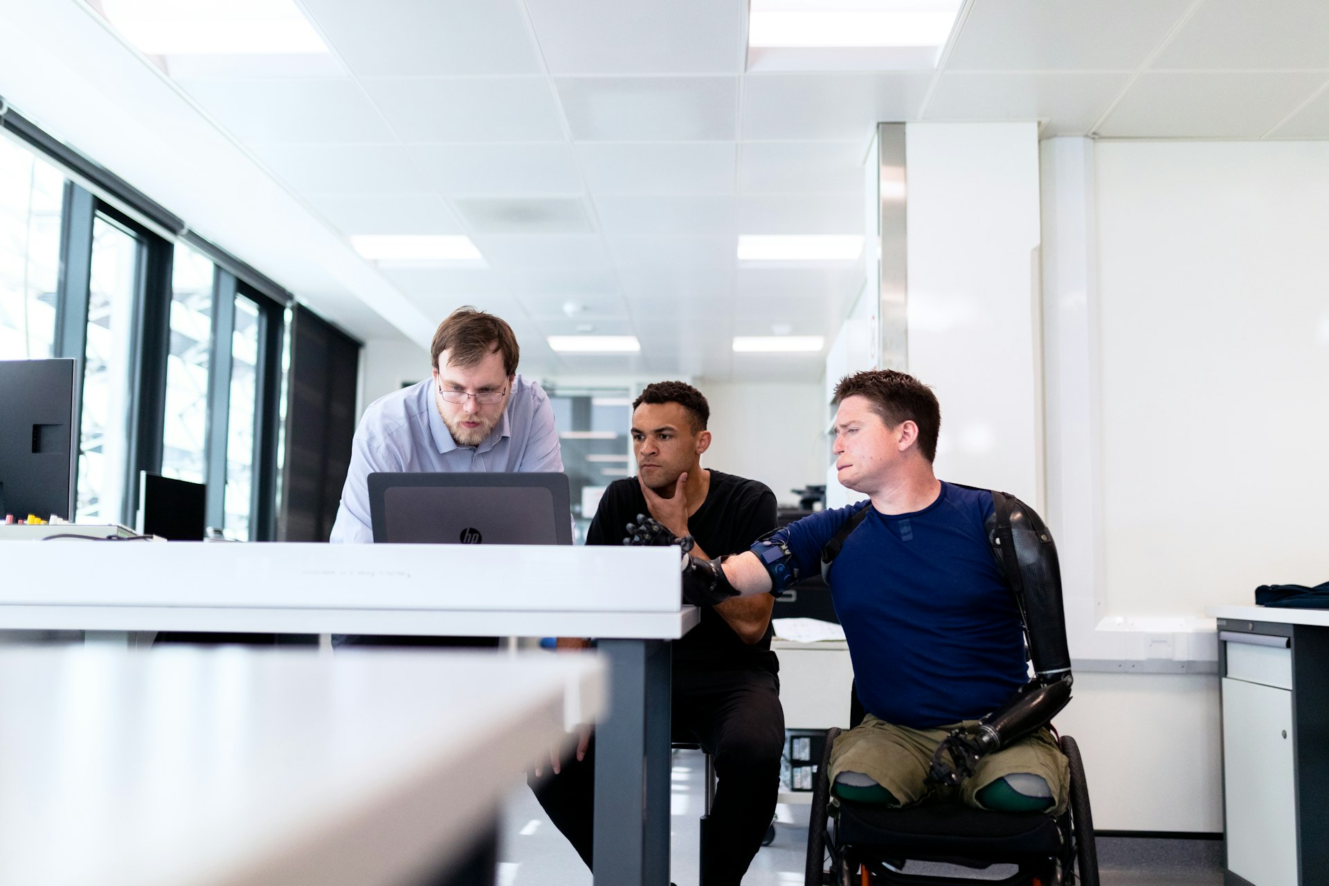 man in blue dress shirt sitting on black office rolling chair